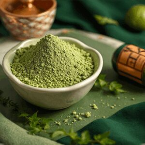 Argile verte naturelle en poudre dans un bol en bois, utilisée pour ses propriétés purifiantes et apaisantes, adaptée pour les humains et les animaux.